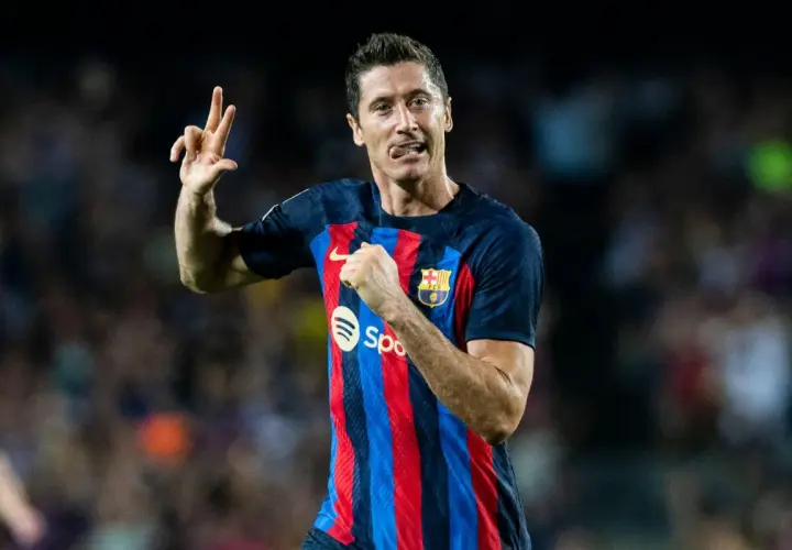 Piłkarz FC Barcelona, Robert Lewandowski, świętuje hat trick, pokazując trzy palce.