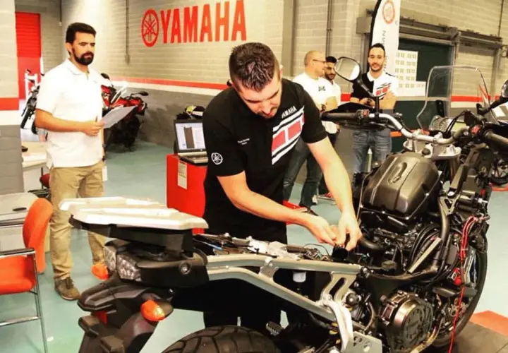 Técnicos trabajando en el motor CP3 de una motocicleta Yamaha.
