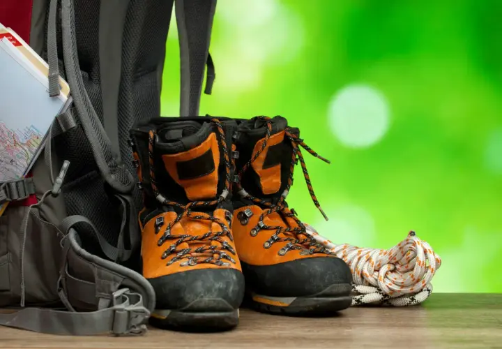 Pomarańczowe buty trekkingowe, plecak i lina. Zadbaj o nie, używając impregnatu do butów z membraną, by były gotowe na każdą wyprawę.