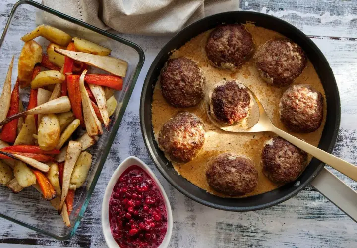 Biffar i ugn i krämig sås, serverade med ugnsrostade rotfrukter och rårörda lingon. En klassisk svensk middag.