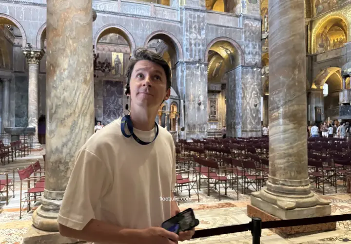 Un homme admire la splendeur de la basilique Saint-Marc, ses yeux levés vers les mosaïques dorées et les colonnes imposantes.