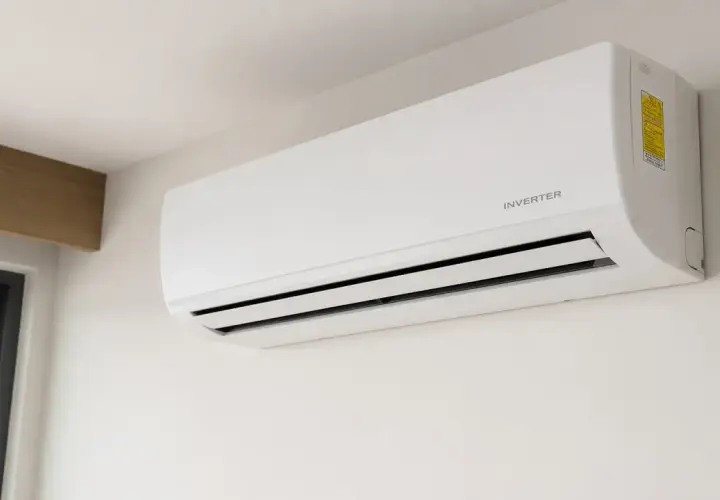 Unidad de aire acondicionado blanca montada en la pared, con la etiqueta "INVERTER" visible.