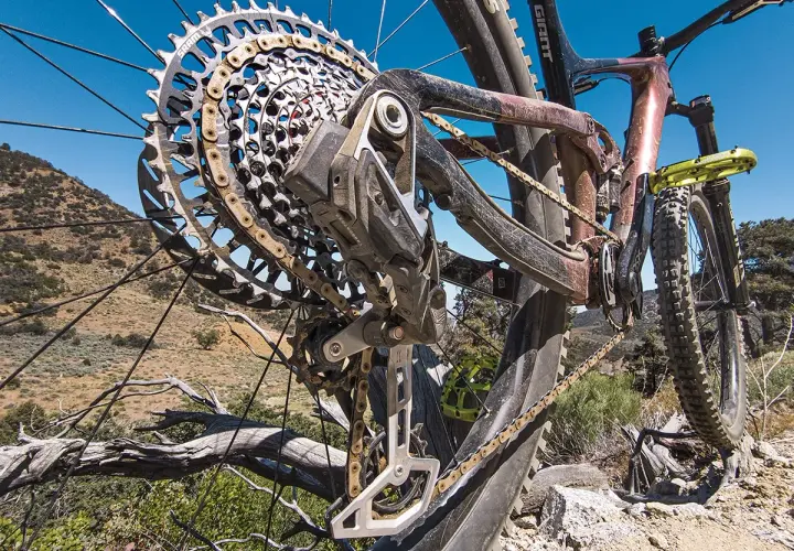 Close-up of a mountain bike's rear derailleur, showcasing its intricate design and the chain. This advanced electronic shifting system ensures smooth gear changes on challenging terrain.