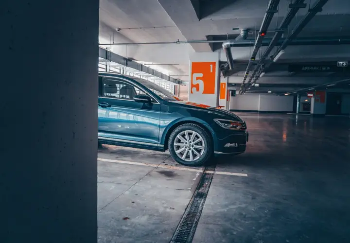 Auto blu parcheggiata nel parcheggio della metro Cipro, con numeri arancioni sulle colonne.