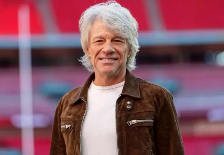 Jon Bon Jovi w brązowej kurtce, uśmiechnięty. Fani marzą o jego **bon jovi koncerty 2026**.