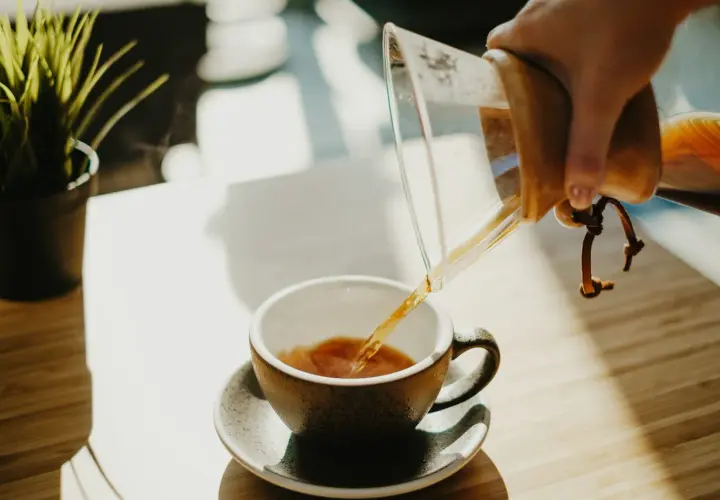 Parzona kawa przelewana z Chemexu do filiżanki. Zastanawiasz się, ile kofeiny ma latte?