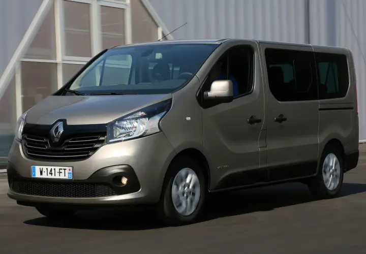 Szary Renault Trafic 3 w ruchu, z widocznym kierowcą za kierownicą.