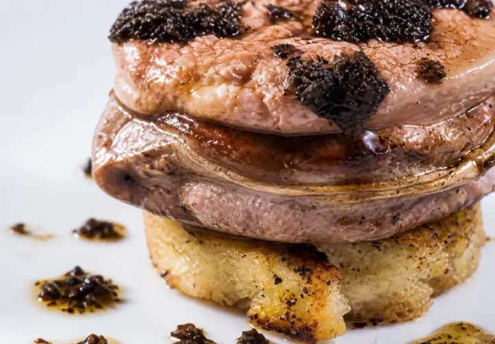 Tournedos Rossini, un délice avec foie gras et truffes. Quel vin avec tournedos rossini ? Un vin rouge corsé comme un Bordeaux ou un Bourgogne.