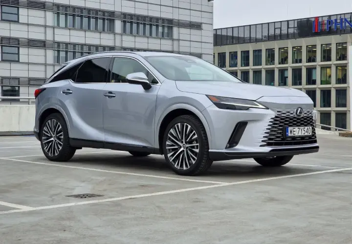Srebrny Lexus 350 zaparkowany przed nowoczesnym budynkiem biurowym.