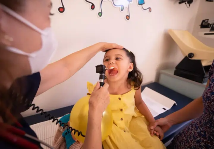 Bambina con gola esaminata da pediatra. Chissà quanto guadagna una pediatra al mese per curare i nostri piccoli.