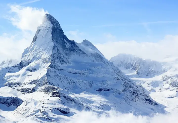 Majestatyczny szczyt Matterhorn, korona Europy, w otoczeniu innych ośnieżonych gór.