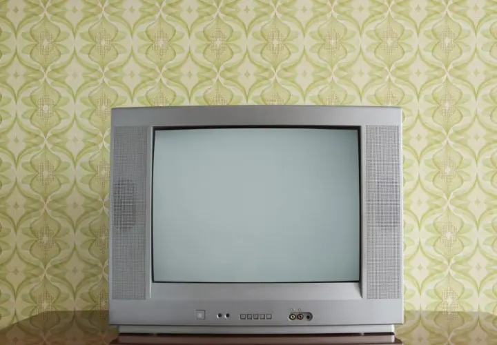 Stary kineskop na tle tapety w zielone wzory. Czekał na ulubiony program.
