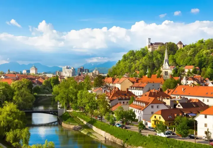Widok na Lublanę, Słowenia. W tle zamek, a na pierwszym planie rzeka. Słowenia jaka waluta? Euro.
