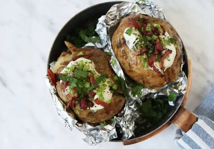 Två bakade potatisar med krämig fyllning, knaprigt bacon och färska örter. En härlig bakad potatis fyllning som ser utsökt ut.