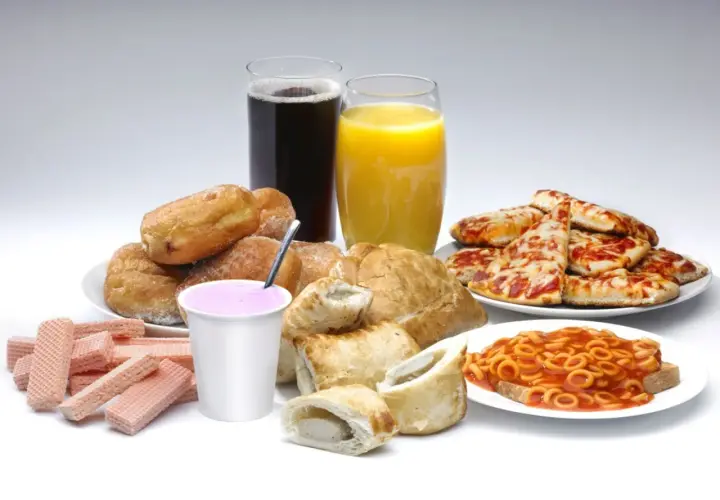Słodkie bułeczki, pizza, słodkie napoje i inne przykłady żywności wysoko przetworzonej.