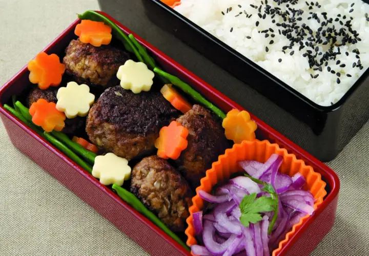 Hamburger bento with meatballs, star-shaped carrots, cheese, green beans, and pickled red onions.