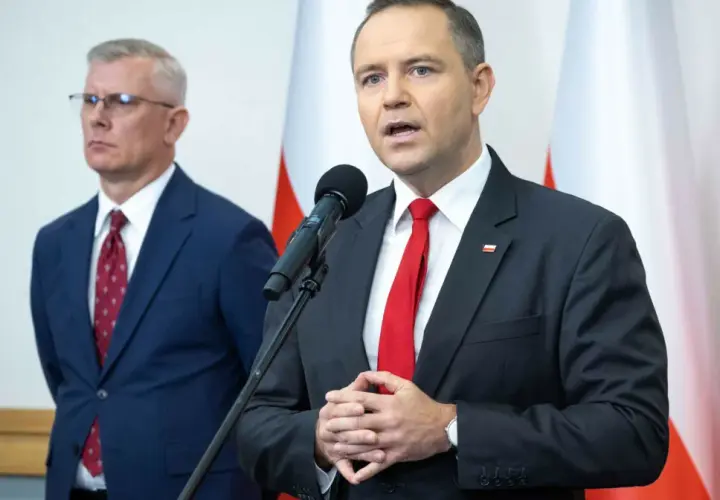 Mężczyzna w garniturze mówi do mikrofonu, obok stoi drugi mężczyzna. Dyskutują, dlaczego prezydent chce zwiększenia budżetu na Biuro Bezpieczeństwa Narodowego o 15 procent.