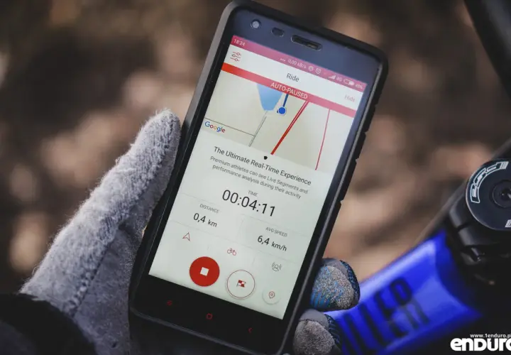 Rękawiczka trzyma smartfon z aplikacją do śledzenia aktywności. Szukasz co zamiast Endomondo? Ta aplikacja pokazuje dystans 0,4 km i średnią prędkość 6,4 km/h.