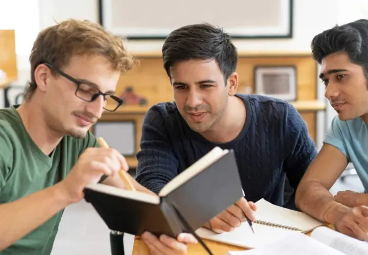Tre studenti collaborano su un progetto, con un libro aperto. Il tempo per studiare è **enough quando si usa** con saggezza.