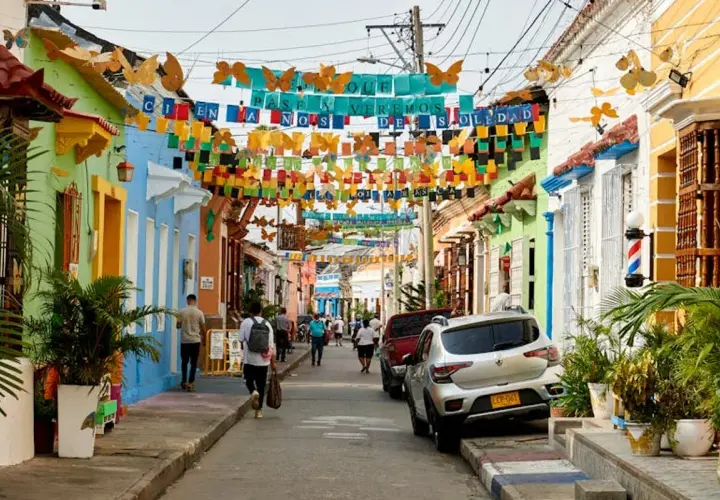 Bunte Häuser und Schmetterlingsgirlanden säumen eine Straße. Perfekt für die beste Reisezeit Curacao, um diese lebendige Atmosphäre zu genießen.