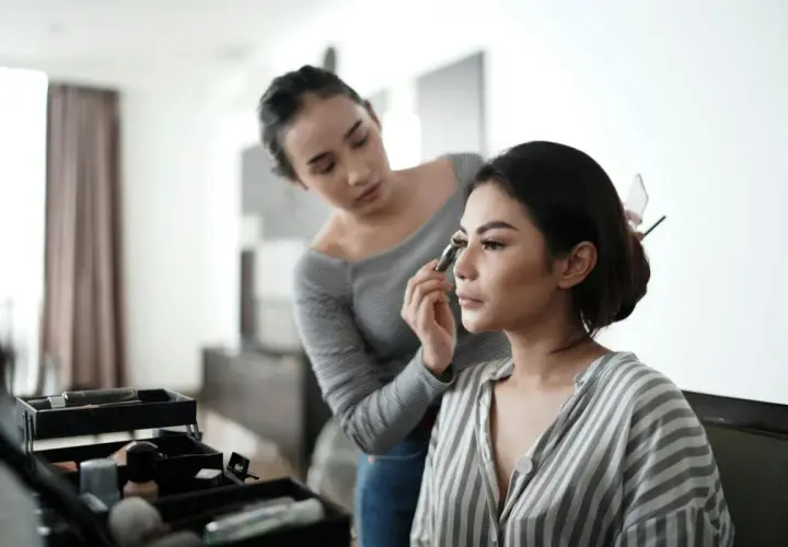 En makeupartist applicerar en silikonbaserad primer på en kvinna.