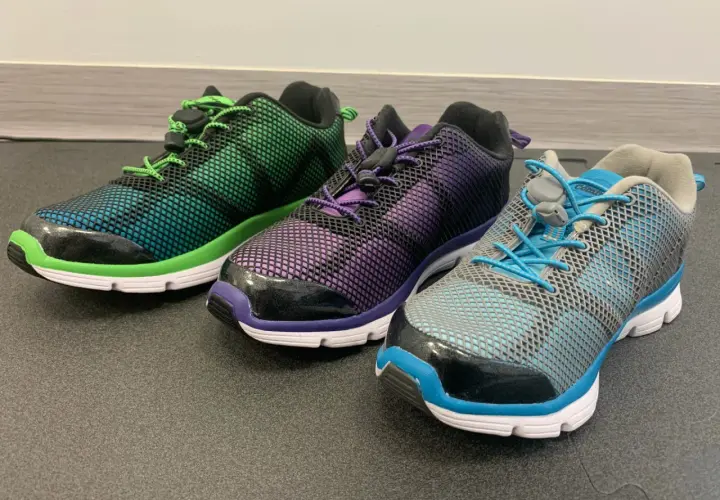 Trzy kolorowe buty sportowe z siateczką i sznurówkami. Idealne, gdy szukasz jakie buty na płaskostopie dla dorosłego.