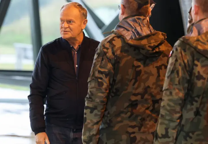 Donald Tusk rozmawia z żołnierzami w mundurach. Czy Donald Tusk był w wojsku? Nie ma informacji, by służył w armii.