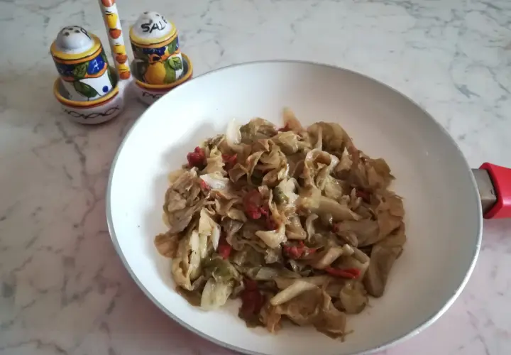 Insalata iceberg cotta in padella con pomodori secchi. Un piatto semplice e gustoso.