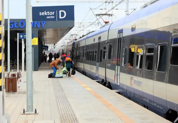 Praca ustawiacz kolejowy na dworcu. Ludzie z bagażami czekają na pociąg PKP Intercity.