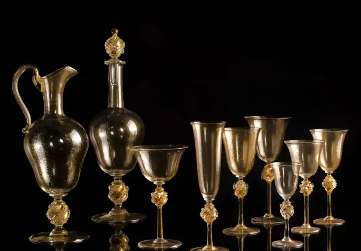Service en verre doré, digne d'un musée du verre à Venise, avec carafe et verres aux pieds sculptés.