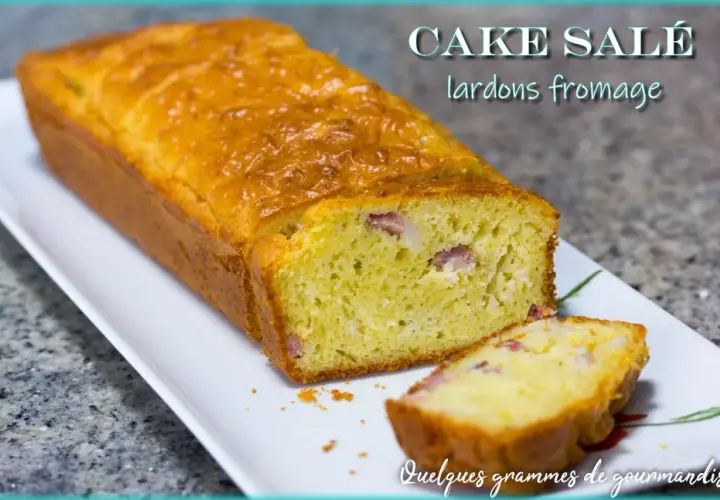 Un cake salé aux lardons et fromage, doré et moelleux, avec une tranche coupée pour révéler les morceaux savoureux.