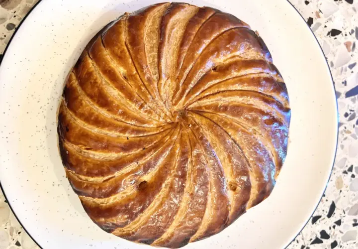 Złocista galette des rois, pieczona do perfekcji, czeka na odkrycie ukrytej w niej figurki.