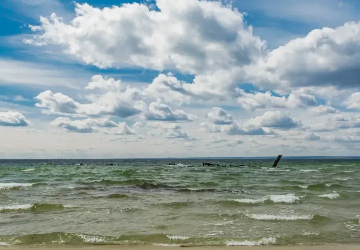 Falujące morze bałtyckie, które jest częścią oceanu atlantyckiego, pod błękitnym niebem z kłębiastymi chmurami.
