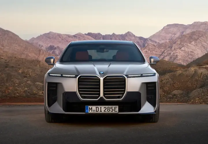Przód luksusowego BMW 7 2025 z charakterystycznym grillem i nowoczesnymi światłami, zaparkowany na tle surowych górskich krajobrazów.