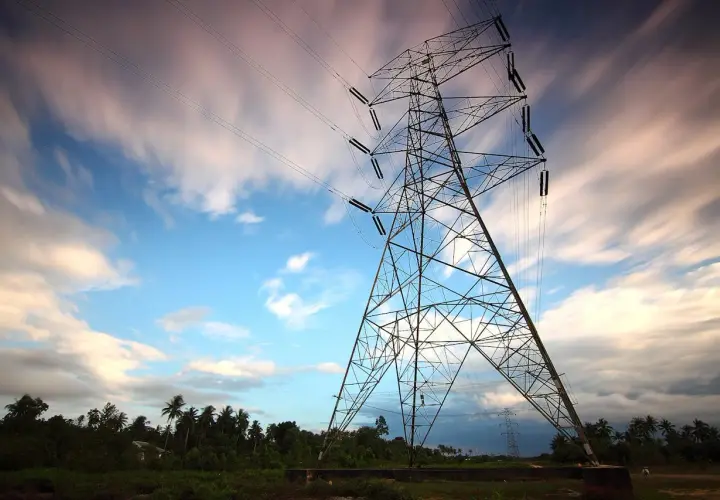 Wieża energetyczna na tle nieba z chmurami, jakby w ruchu. Taryfa g13 zapewnia energię.