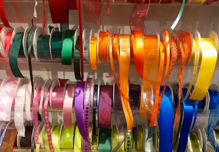 Rouleaux de rubans colorés, de différentes textures et motifs. Ces rubans servent à décorer, emballer, et à ajouter une touche de fantaisie aux vêtements.
