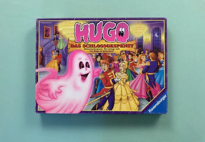 Das Cover des Hugo Spiels zeigt ein rosa Gespenst, das eine Ballgesellschaft erschreckt. Wer ist mutig genug, sich vor Hugo in Sicherheit zu bringen?