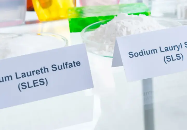 Dwa białe proszki w naczyniach laboratoryjnych: Sodium Laureth Sulfate (SLES) i Sodium Lauryl Sulfate (SLS).