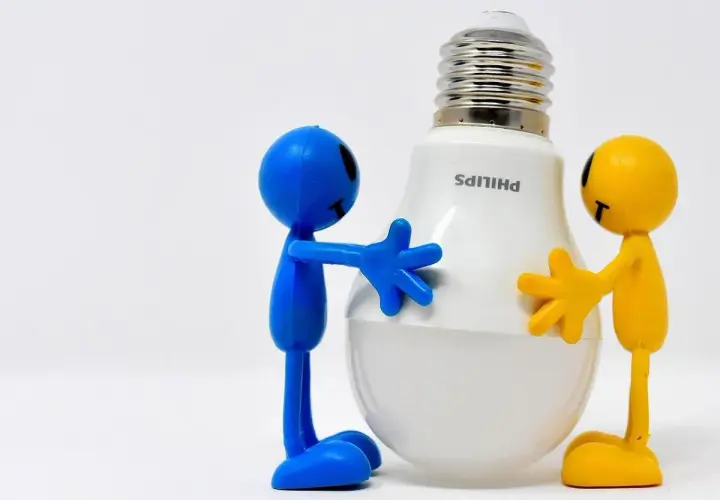 Due pupazzi, uno blu e uno giallo, abbracciano una lampadina LED Philips. Un modo divertente per ricordare come risparmiare energia in casa.