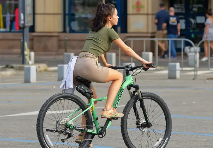 Dziewczyna na rowerze, która uczy się, jak zmieniać przerzutki w rowerze, by jazda była płynniejsza.
