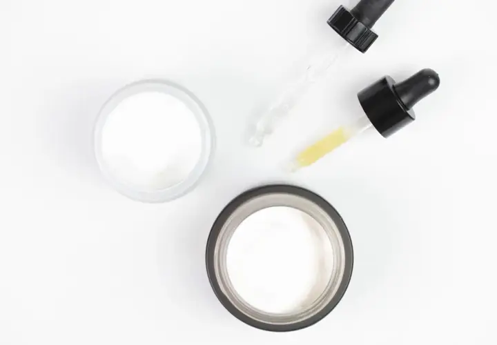 Dwa słoiczki kremu i pipetki z serum, jedno z nich zawiera kwas salicylowy.