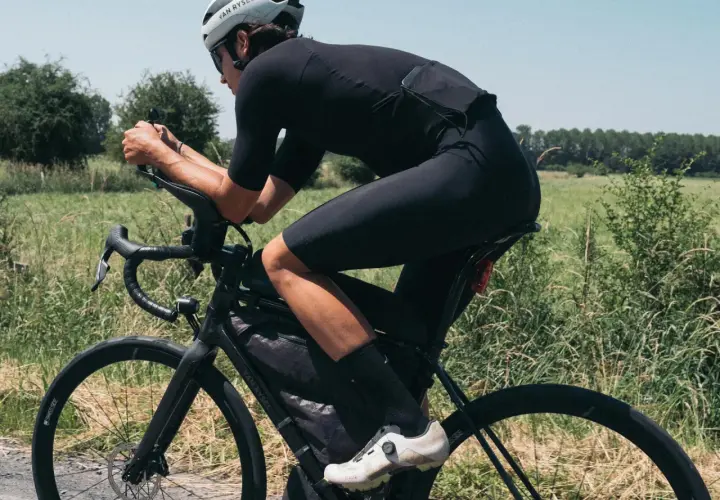 Kolarz w aerodynamicznej pozycji, dbający o swój kręgosłup lędźwiowy podczas jazdy.