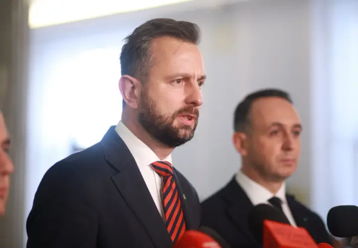Politycy w garniturach, jeden z nich przemawia. Fani polityki spekulują o dymisji ministra rolnictwa przed marcem 2026.