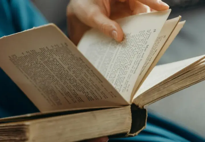 Eine Hand blättert in einem alten Buch. Der Titel "Man and Superman" ist sichtbar. Ein guter historischer Roman zum Eintauchen.