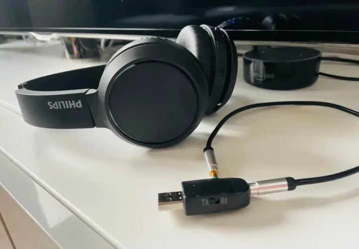 Czarne słuchawki Philips z adapterem USB-jack, pokazujące, jak podłączyć słuchawki do telefonu Samsung.