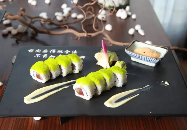 Sushi z zielonym ikrą, podane z wasabi, marynowanym imbirem do sushi i sosem.