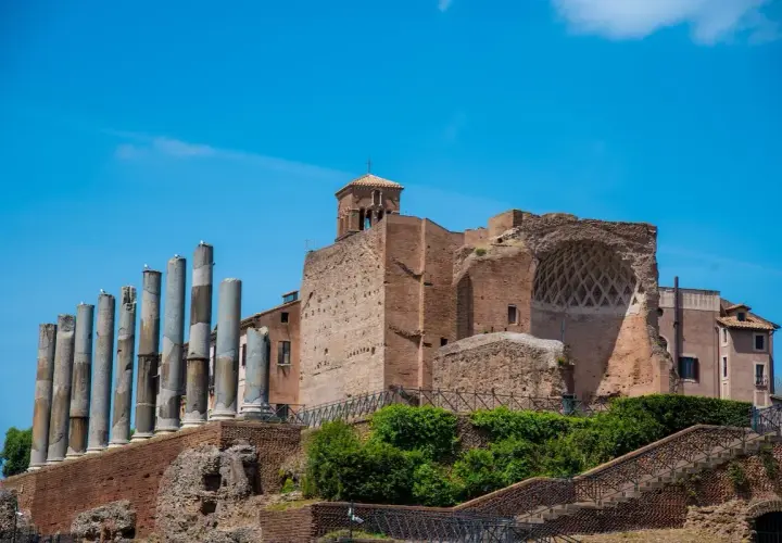 Resti antichi a Roma, tra cui colonne e mura di mattoni, evocano la grandezza della Domus Aurea.