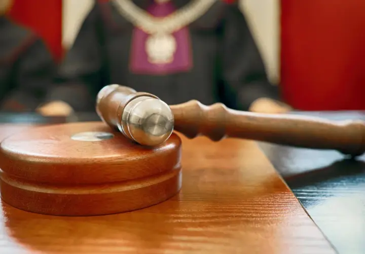 Młotek sędziowski na stole. Sąd rozstrzyga, czy odpowiedź na apelację doręcza się bezpośrednio pełnomocnikowi.