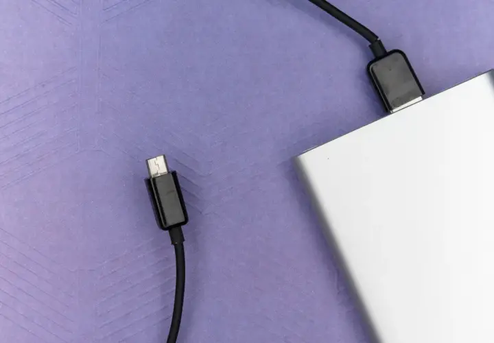 Srebrny powerbank, niezbędny w bagażu podręcznym, gotowy do ładowania urządzeń w podróży.
