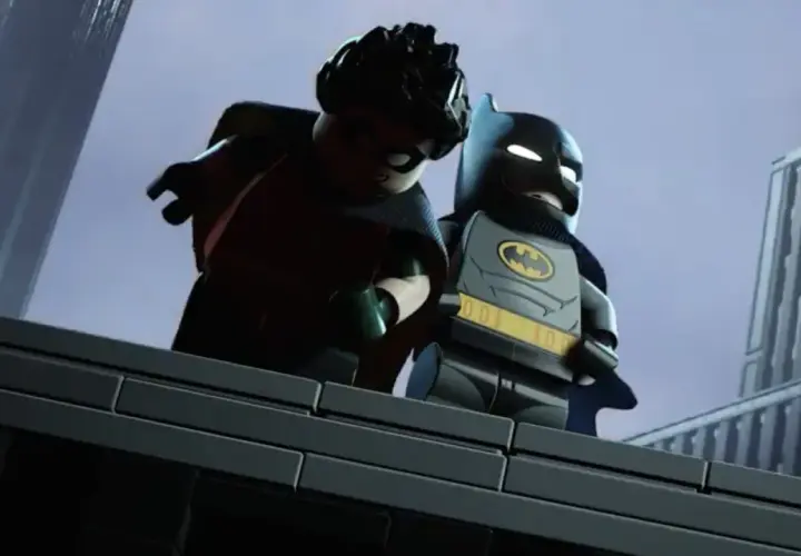 Batman et Robin, en Lego, sur un toit. Batman semble donner une leçon à Robin.
